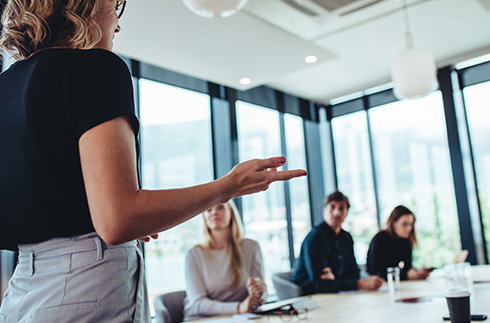 business meeting with speaker presenting to two attentive colleagues in modern office setting